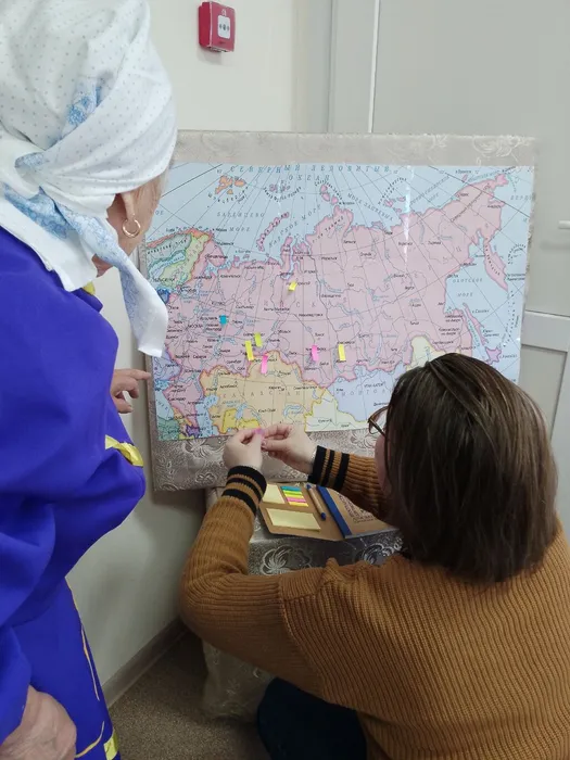 Гости библионочи прикрепляют стикеры на карте России, выбирая город откуда их предки