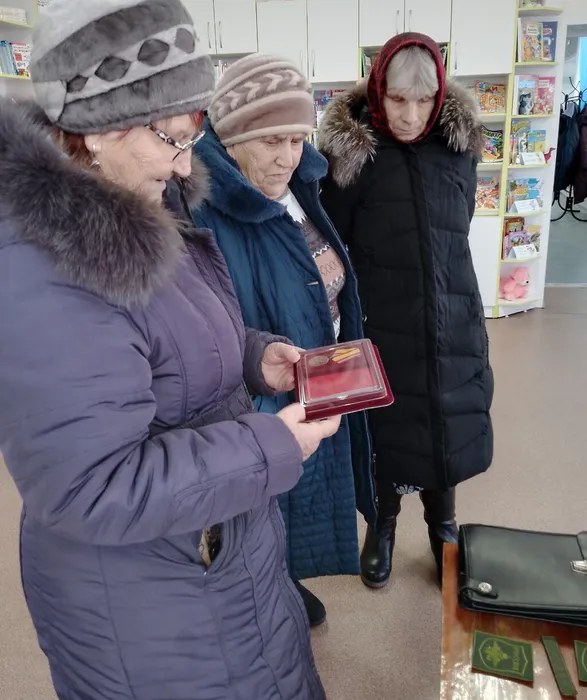 Женщины знакомятся с медалью