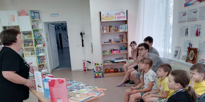библиотекарь рассказывает ребятам о новых книгах, поступивших в библиотеку